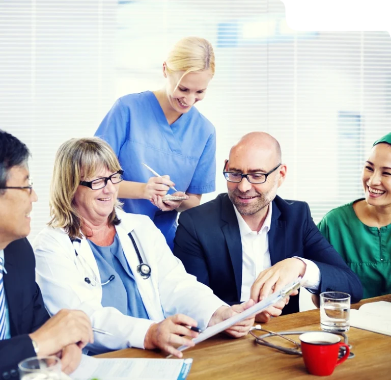 Medical and admin team discussing billing process with documents and tablet